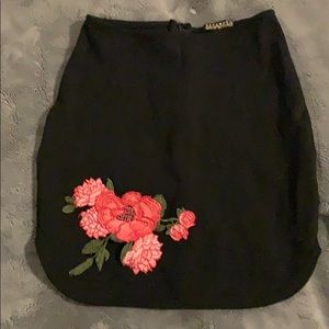 A black skirt with cute flowers on the corner